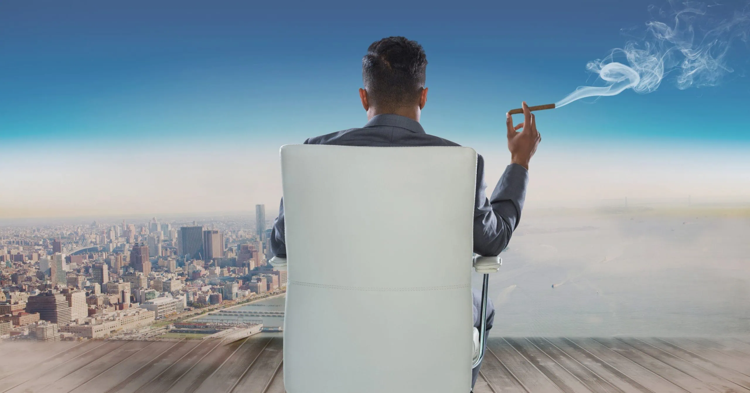 Rear view of businessman sitting on chair smoking cigar overlooking city
